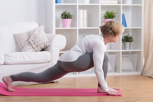 Mulher a realizar uma flexão de braços em casa