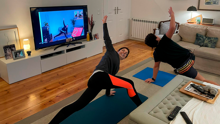 Duas pessoas a treinar numa sala com orientação por videochamada
